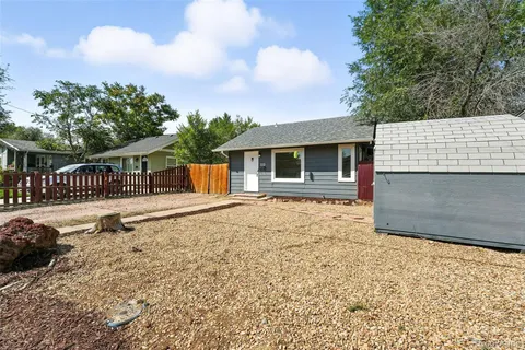 a backyard of a house with table and chairs