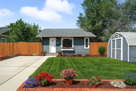 a front view of house with yard and trees in the background