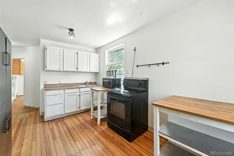 a kitchen with a sink cabinets stainless steel appliances and a window