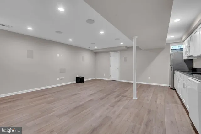 a kitchen with a refrigerator and white cabinets