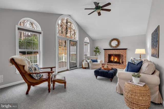 a living room with furniture a fireplace and a large window