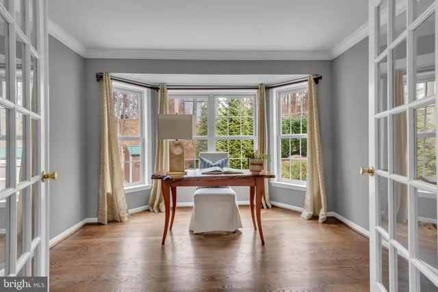 a dining room with wooden floor a chandelier a wooden table and chairs