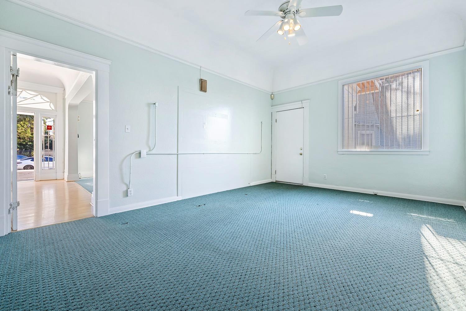 235 North Fulton Street Fresno, CA 93701 - Photo 19 of 43 an empty room with chandelier fan and windows