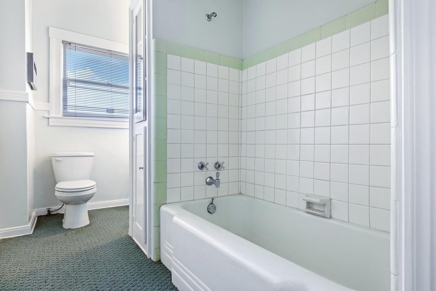 235 North Fulton Street Fresno, CA 93701 - Photo 25 of 43 a bathroom with a bathtub and toilet