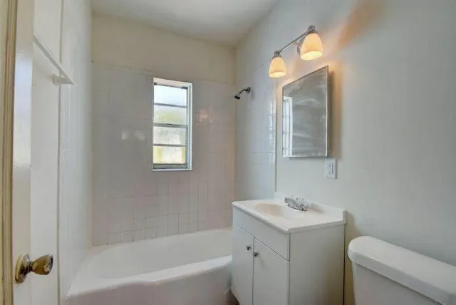 a bathroom with a sink mirror vanity and toilet