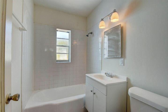 3000 Broadway Avenue, Unit 3 West Palm Beach, FL 33407 - Photo 13 of 19 a bathroom with a sink mirror vanity and toilet