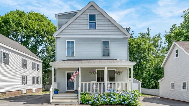 a view of a white house with a potted plant and a large window