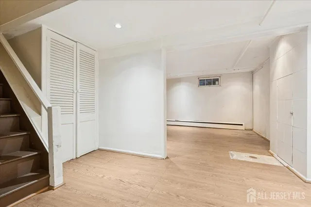 a view of empty room with wooden floor and electronic appliances