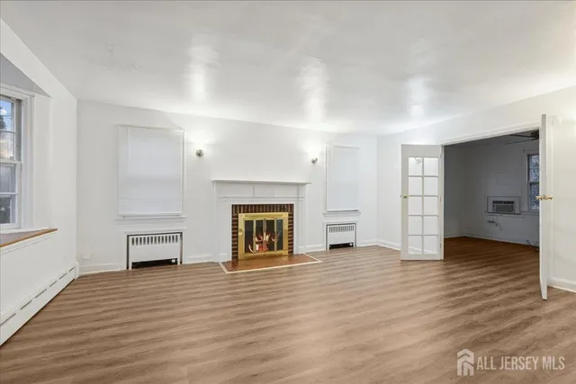 an empty room with wooden floor and fireplace
