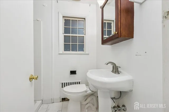 a bathroom with a sink toilet and a mirror