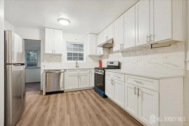 a kitchen with white cabinets and white appliances