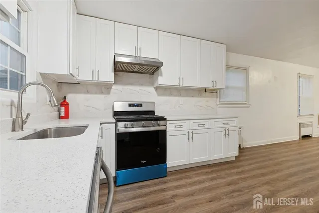 a kitchen with stainless steel appliances a sink stove and cabinets