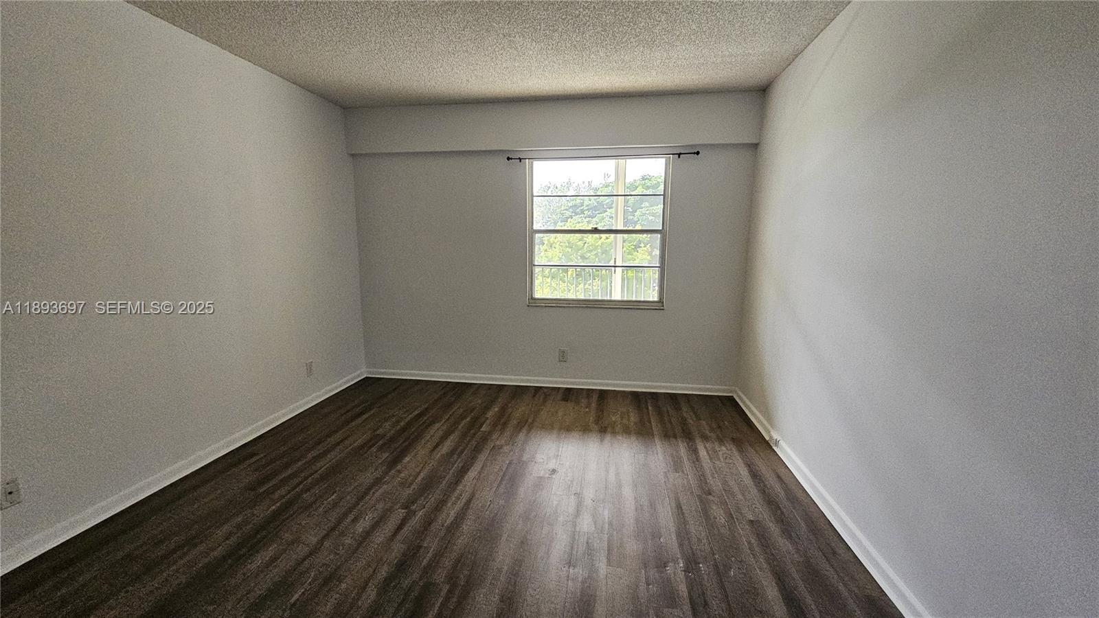 13450 Southwest 3rd Street, Unit 415D Pembroke Pines, FL 33027 - Photo 11 of 15 an empty room with wooden floor and windows