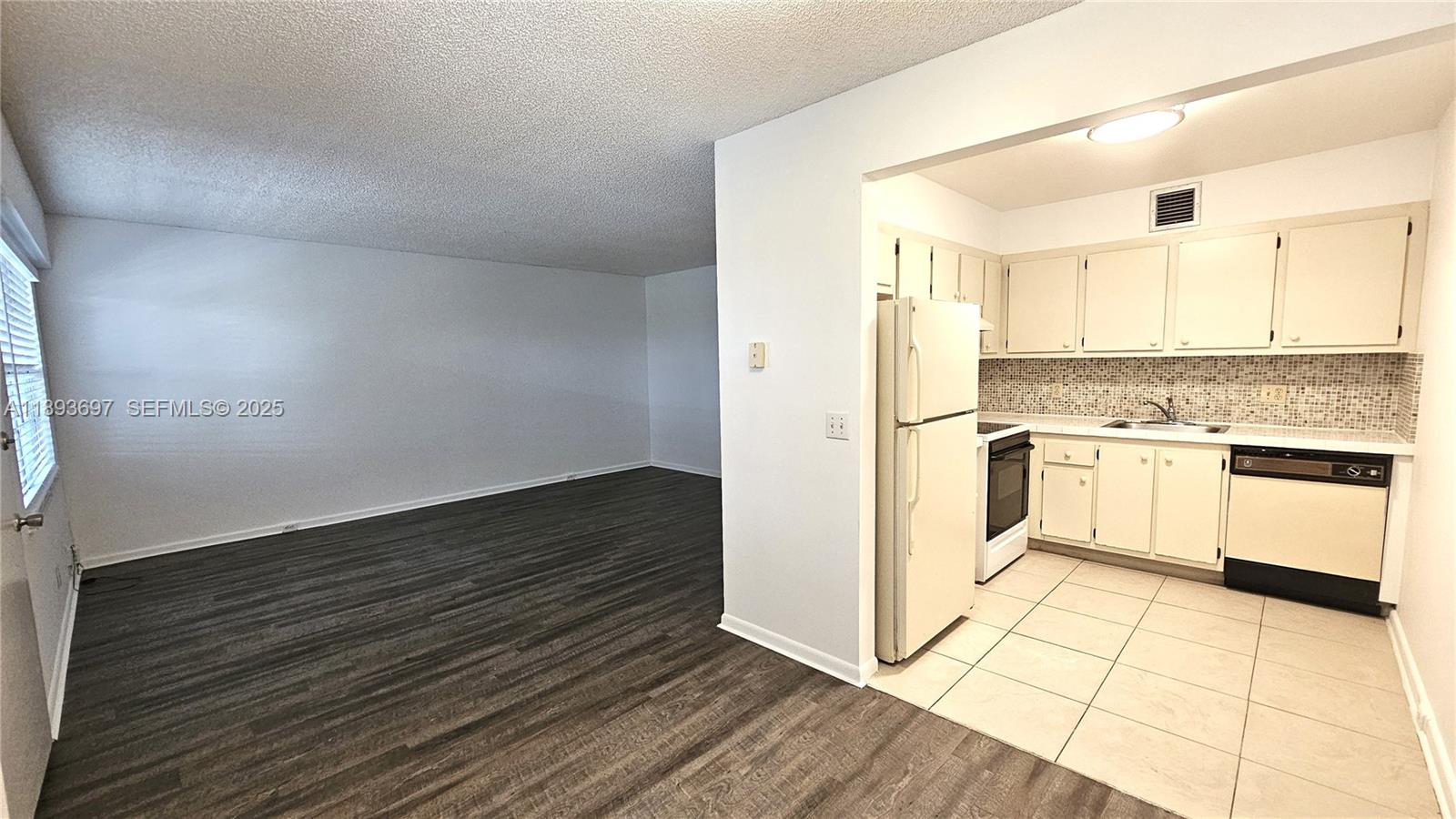 13450 Southwest 3rd Street, Unit 415D Pembroke Pines, FL 33027 - Photo 3 of 15 a kitchen with granite countertop white cabinets and white appliances