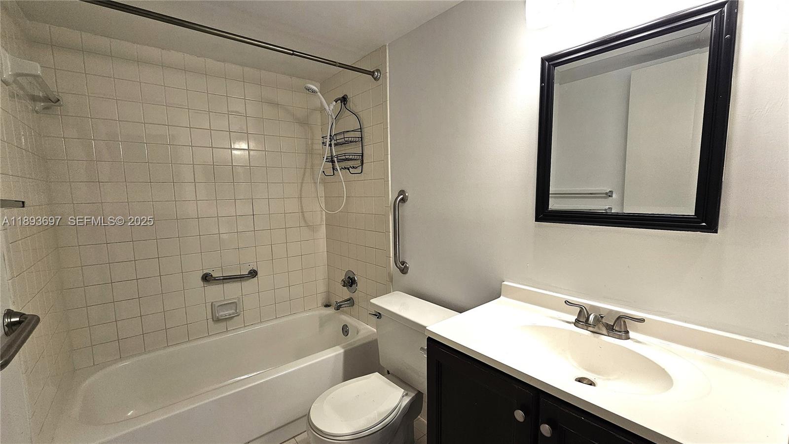 13450 Southwest 3rd Street, Unit 415D Pembroke Pines, FL 33027 - Photo 5 of 15 a bathroom with a bathtub shower sink mirror vanity and a toilet