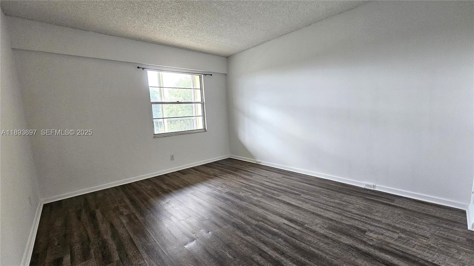13450 Southwest 3rd Street, Unit 415D Pembroke Pines, FL 33027 - Photo 7 of 15 an empty room with wooden floor and windows