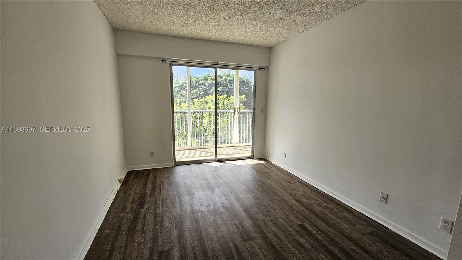 13450 Southwest 3rd Street, Unit 415D Pembroke Pines, FL 33027 - Photo 10 of 15 a view of an empty room with wooden floor and a window
