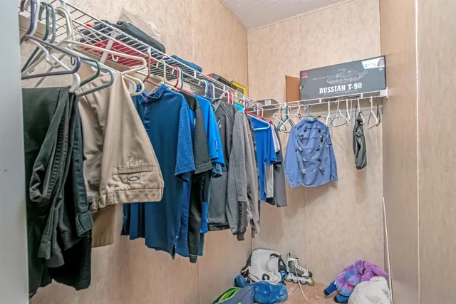 a view of walk in closet with clothes and shoes