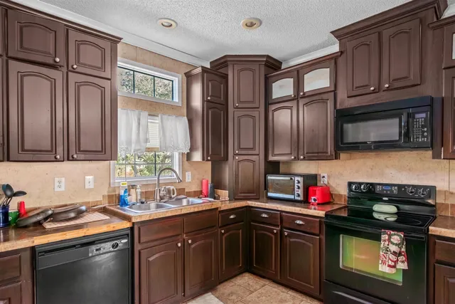 a kitchen with stainless steel appliances granite countertop a sink stove and cabinets