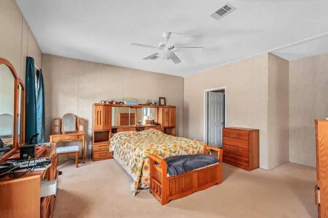 a bedroom with a bed and dresser with mirror