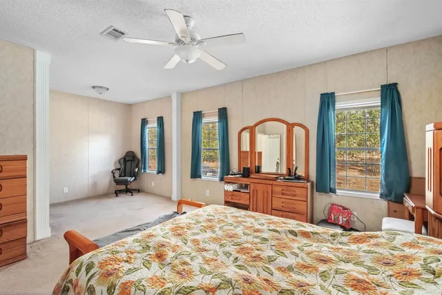 a bedroom with a bed and a large window with the outer view