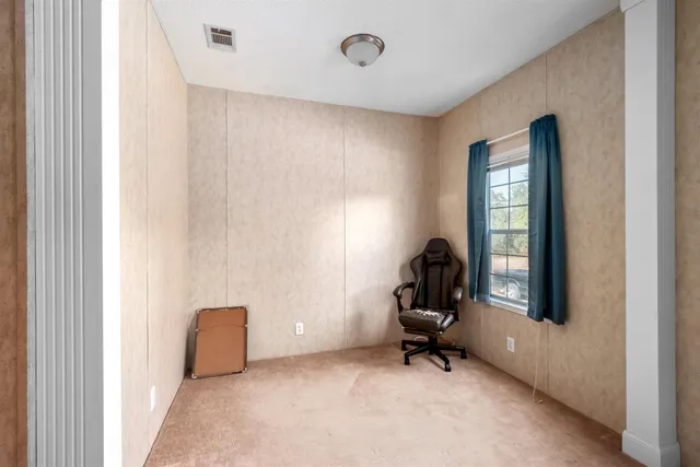 a view of a workspace with furniture and a window