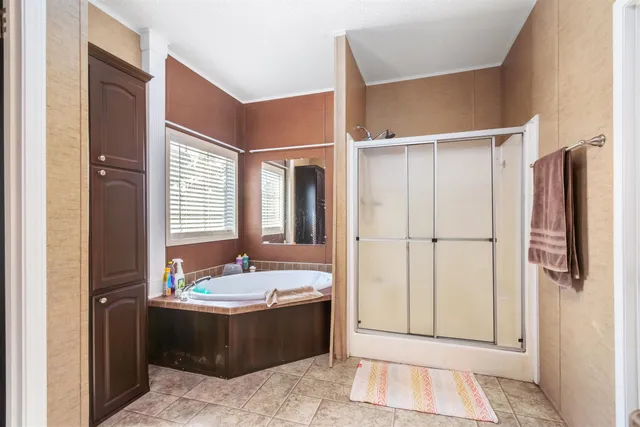 a view of bathroom with tub shower and mirror