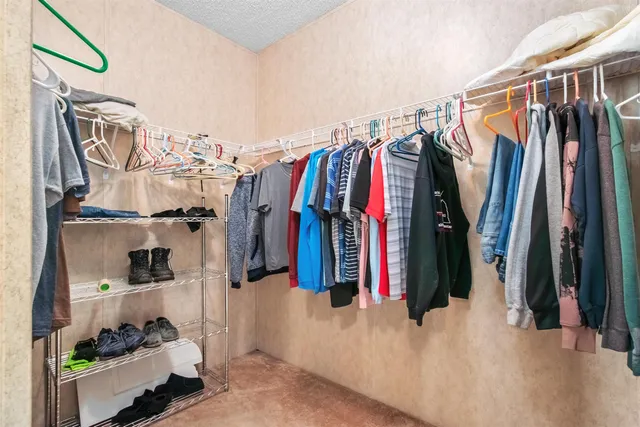 a view of walk in closet with clothes and shoes