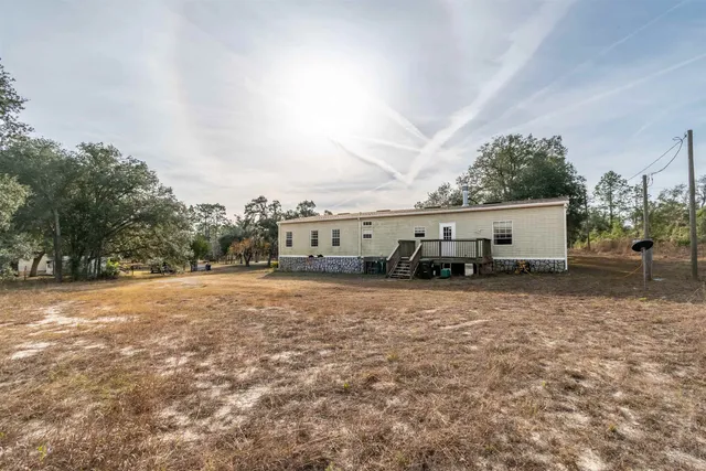 a view of a house with backyard and trees