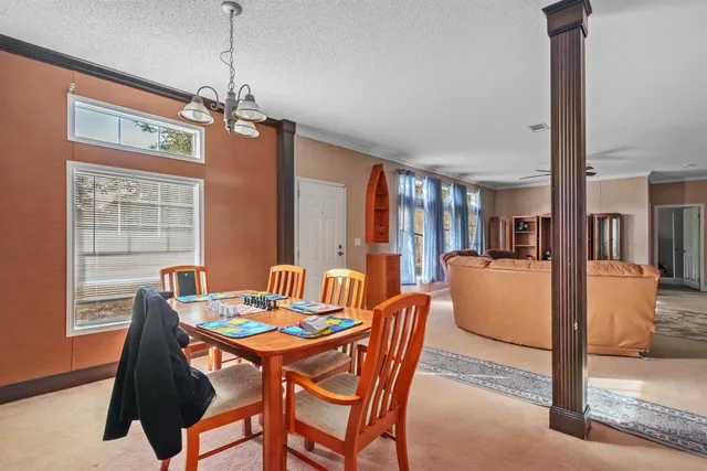 a dining room with furniture a chandelier and window