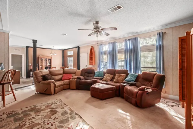a living room with furniture ceiling fan and a window