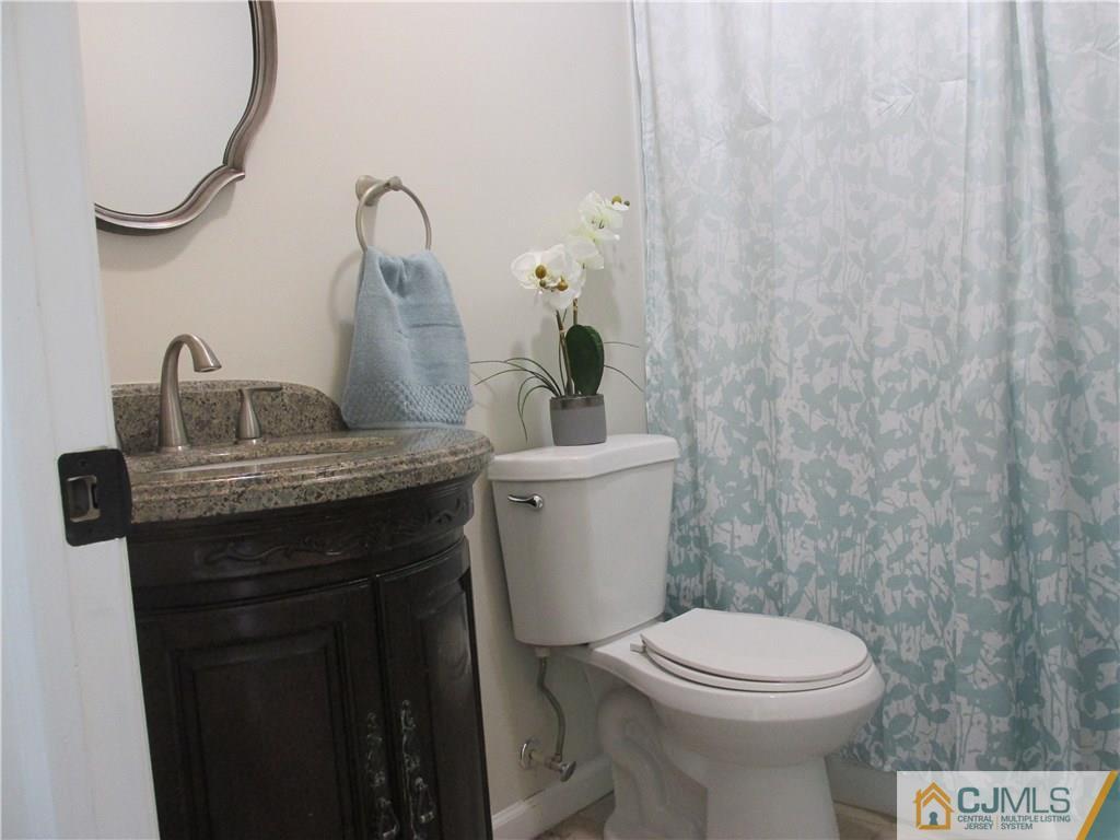 111 Winthrop Road Edison, NJ 08817 - Photo 8 of 10 a bathroom with a granite countertop sink a toilet and a mirror