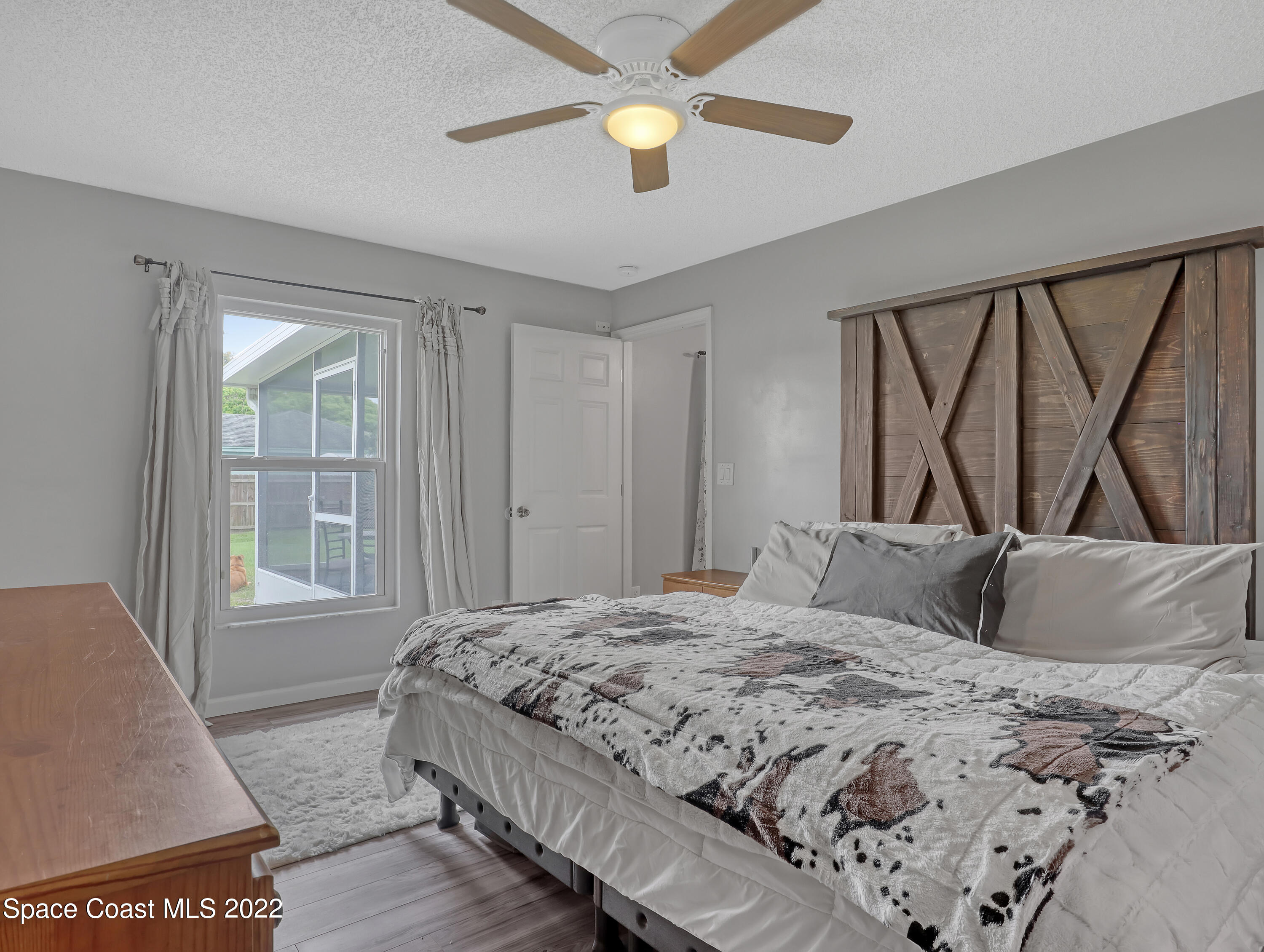 7010 Bayfront Road Cocoa, FL 32927 - Photo 14 of 36 a bedroom with a large bed and a chandelier