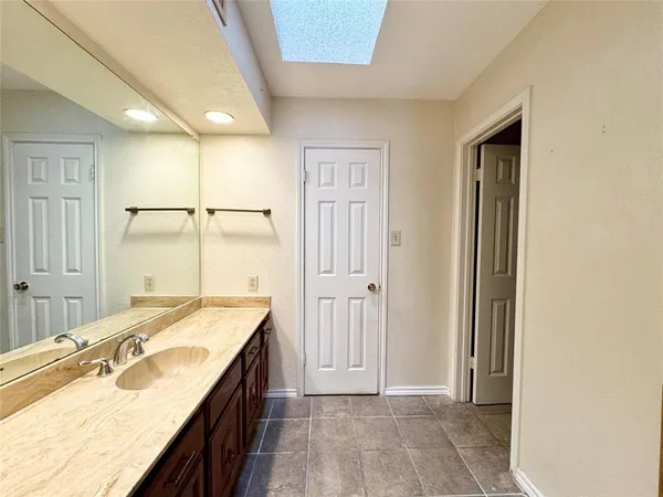 a bathroom with a granite countertop sink a mirror and a shower