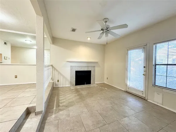 an empty room with fan and windows