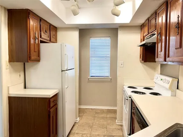 a kitchen with a refrigerator and a stove top oven