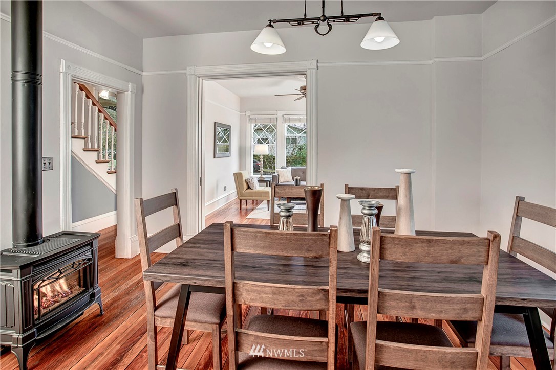 815 20th Avenue South Seattle, WA 98144 - Photo 11 of 33 a dining room with wooden floor a chandelier a wooden table and chairs