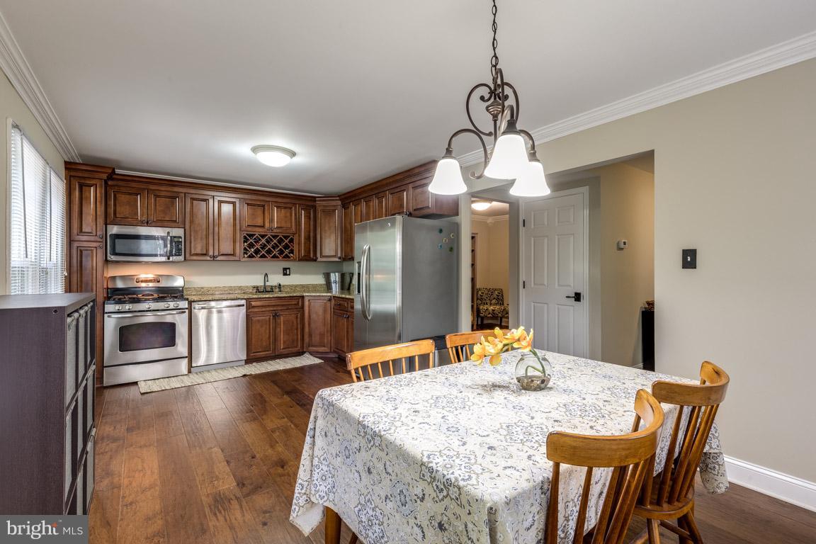 11841 Dunlop Court Reston, VA 20191 - Photo 11 of 30 a kitchen with stainless steel appliances granite countertop a sink a stove a refrigerator with a dining table and chairs