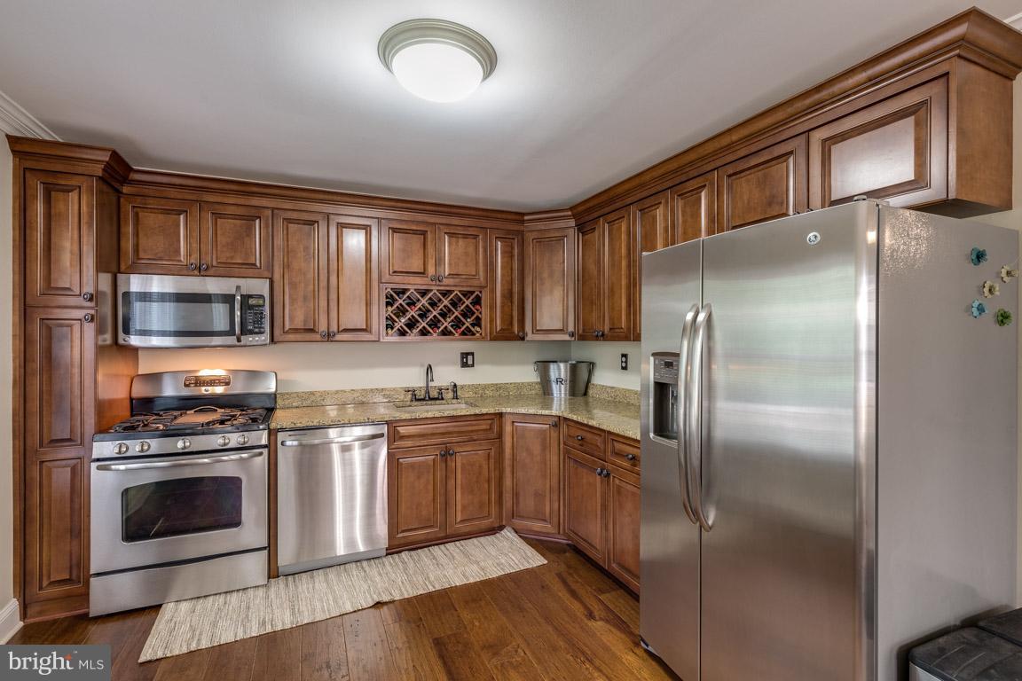 11841 Dunlop Court Reston, VA 20191 - Photo 12 of 30 a kitchen with stainless steel appliances granite countertop a stove top oven a sink and dishwasher a refrigerator with wooden floor