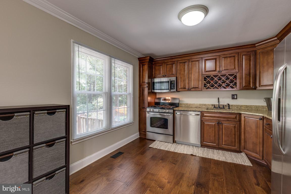 11841 Dunlop Court Reston, VA 20191 - Photo 13 of 30 a kitchen with stainless steel appliances granite countertop a stove top oven a sink and a granite counter tops with wooden floors