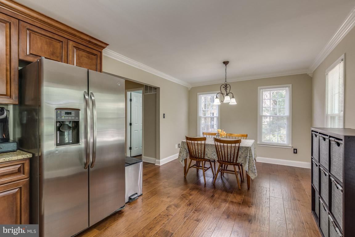 11841 Dunlop Court Reston, VA 20191 - Photo 14 of 30 a dining room with furniture a chandelier and wooden floor
