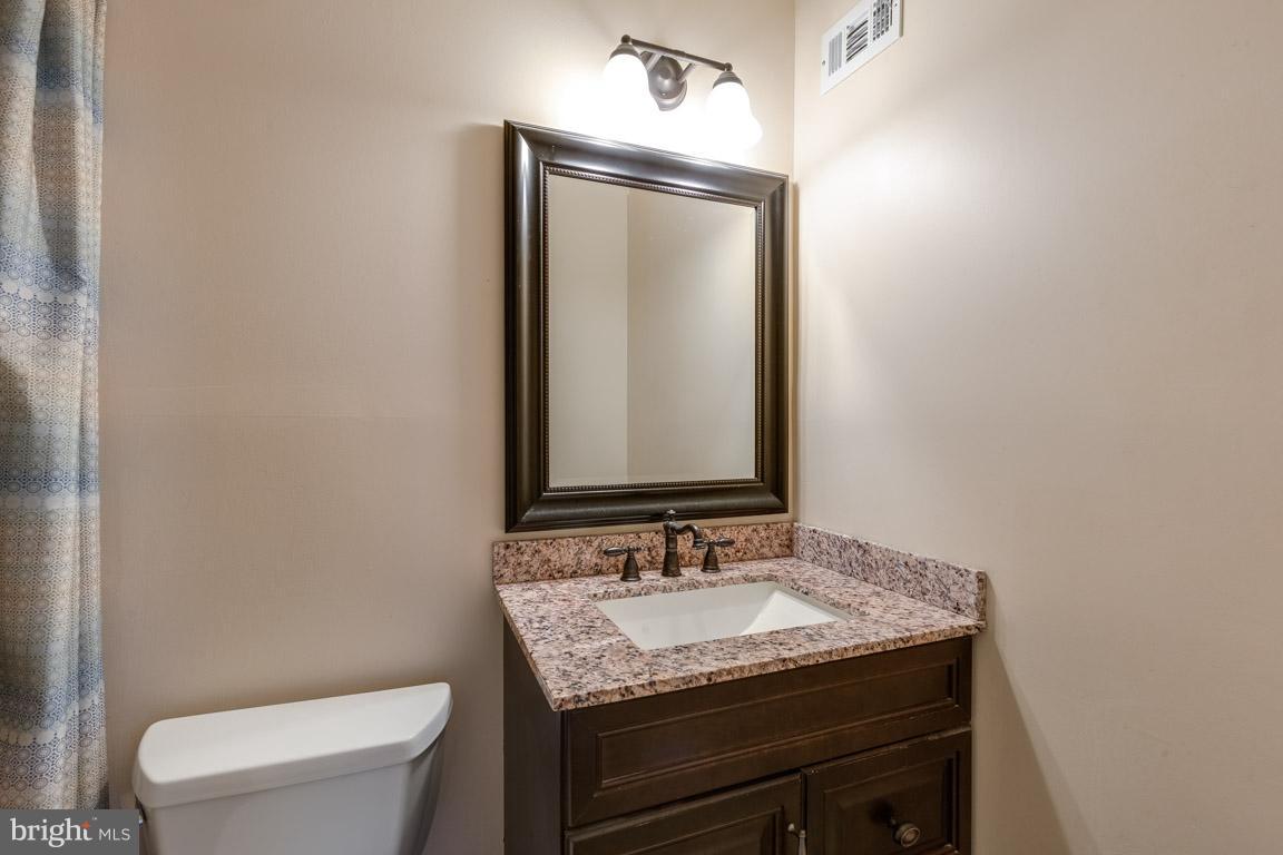 11841 Dunlop Court Reston, VA 20191 - Photo 26 of 30 a bathroom with a granite countertop sink toilet and mirror