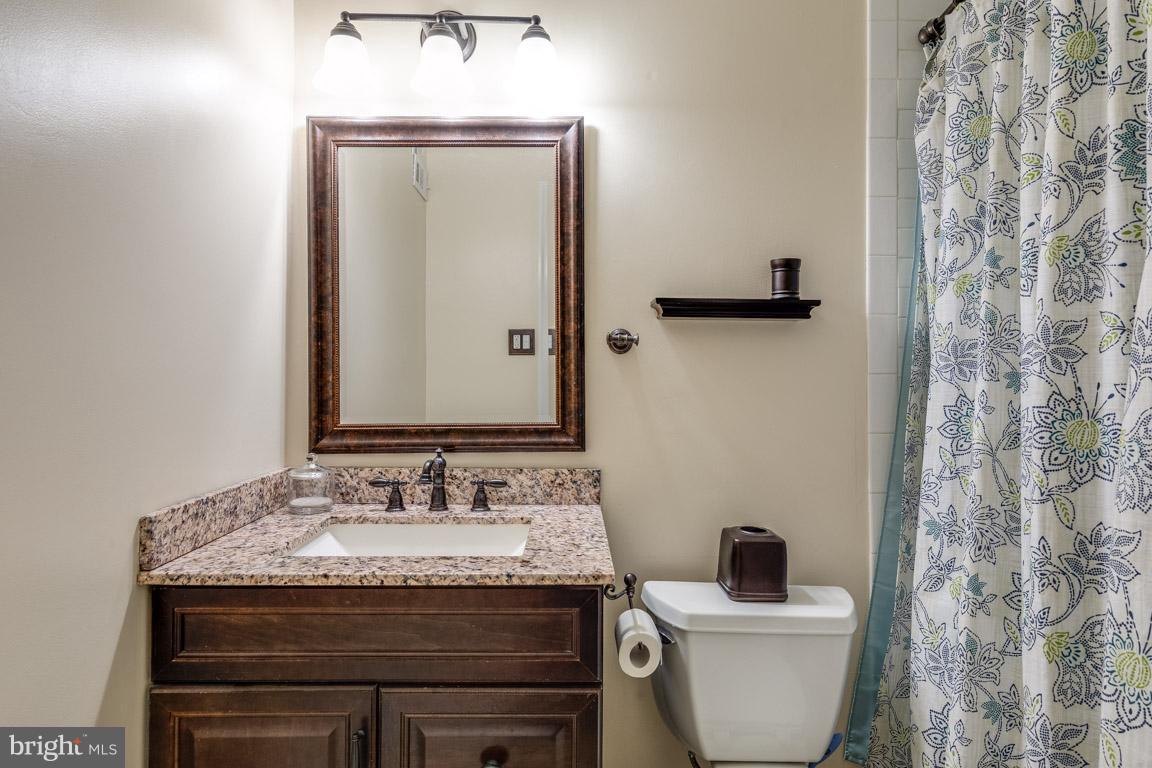 11841 Dunlop Court Reston, VA 20191 - Photo 28 of 30 a bathroom with a granite countertop sink a toilet and a mirror