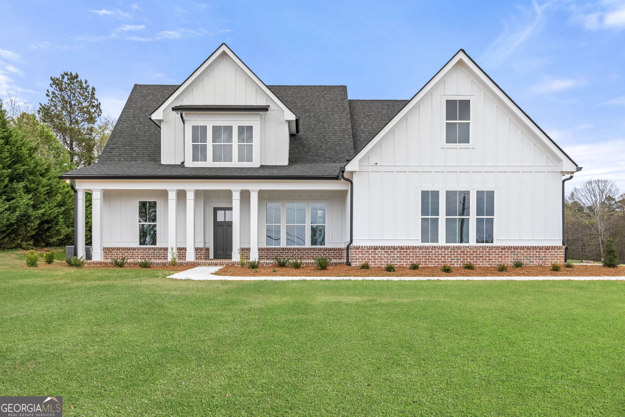a front view of a house with a garden and plants