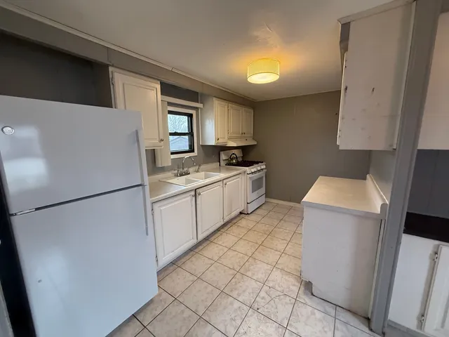 a kitchen with a refrigerator sink stove and cabinets
