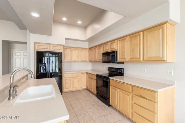 a kitchen with granite countertop a sink stainless steel appliances and cabinets