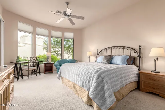 a bedroom with a bed lamps and chairs