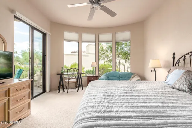 a bedroom with a large bed and a flat tv screen on dresser