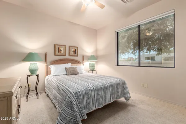 a bedroom with a bed and a painting on the wall