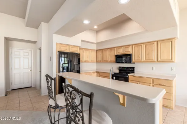 a kitchen with stainless steel appliances a stove a sink a microwave a dining table and chairs